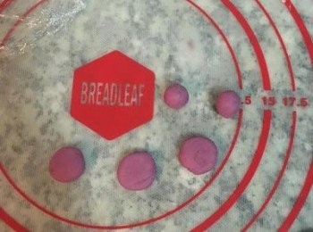 step21: 另外再取80g紫薯麵糰，分割成40顆，每顆約2g，揉圓後略壓扁，用手沾點水黏在中間紫薯麵糰的上方空位處即可。
麵糰揉圓時如過乾，可用手指沾濕後再搓。