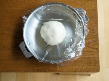 step4: 將剩餘的橄欖油，一部份塗在平底鑊上，再放上麵團，將另一小部份橄欖油用掃掃在粉團上。用保鮮紙蓋好，在室溫靜置兩小時。