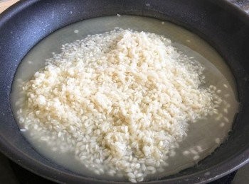 step2: 燒紅鑊，加入10克牛油、蒜片、蘑菇、20克白酒及少量海鹽，炒至七八成熟，盛起備用，煮出的蘑菇水留起。
燒紅鑊，加入15克牛油、意大利米、20克白酒，以中火慢炒。
待意大利米吸收白酒後，逐少加入雞湯，及後逐少加入清水及蘑菇水，以中火慢炒25分鐘。