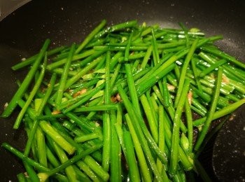 step4: 韭菜花下鑊後炒一炒，加水蓋蓋焗一陣，打開蓋後加少許鹽和糖炒混即成。