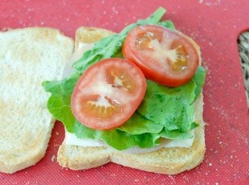 step3: 將麵包切邊、烘成多士、塗上牛油，在上面放一片芝士－＞火腿－＞生菜－＞蕃茄，然後加點茄汁和沙律醬