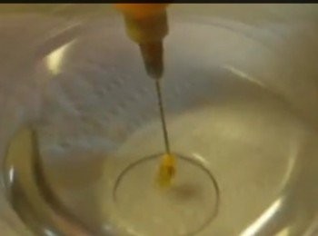 step4: 首先用小匙在啫喱中心拔走少許啫喱方便刺針筒注射。注入黃色椰漿的針筒刺入啫喱中心，注射6至8針做出花芯。