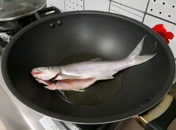 step4: 慢火燒熱油， 放進魚， 魚肚開口一方向上；