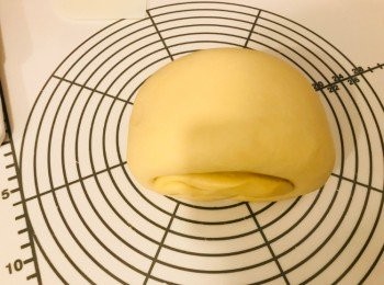 step4: 枱上灑上高筋麵粉，將第一次發酵完成的麵團空氣拍出，用木棍擀成長方形，先將1/3麵團摺上，再將1/3麵團摺下，捲起，包上保鮮紙，靜置10分鐘