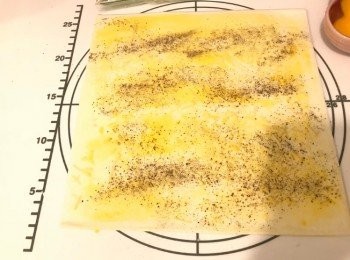 step3: 鋪上一塊酥皮及掃上蛋液，灑上適量芝士碎及黑椒碎