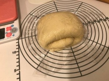 step4: 枱上灑上高筋麵粉，將第一次發酵完成的麵團空氣拍出，用木棍擀成長方形，先將1/3麵團摺上，再將1/3麵團摺下，捲起，包上保鮮紙，靜置10分鐘