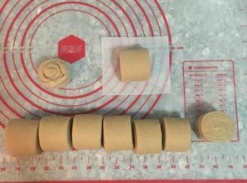 step16: 裁切掉兩邊，並將切口合再一起，等一下一樣可以蒸，不需丟棄；接著裁切每顆約4公分的大小，連邊緣的那顆，總共為九顆；拿取時從裁切面輕輕拿起，收口朝下的放在饅頭紙上，並排入蒸籠中；