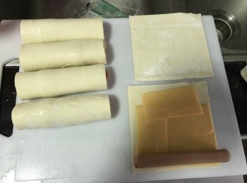 step1: 先預熱焗爐200度10分鐘
在酥皮上放上芝士片和香腸，捲起來