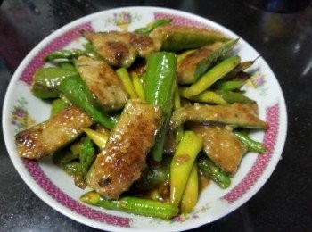 step9: 鯪魚肉先用雞粉 , 糖 , 生粉 , 胡椒粉撈至起膠 , 將尖椒清洗去籽後 , 隔乾水份切開一半 , 在尖椒內上少少生粉 , 再將鯪魚肉釀入尖椒內 , 而露荀切成小段。
燒紅油鑊爆香蒜頭 , 乾蔥爆炒露荀 , 少少糖 , 鹽炒至轉翠綠色半熟上碟。 
再起鑊用細火將尖椒放入 , 慢煎封魚肉至金黃色 , 之後再加約 200ml 水 , 將露荀回鑊 , 放入黃豆醬 , 少少糖 , 少少胡椒粉 , 轉大火煮至收汁 , 完成。
注意 - 因有黃豆醬 , 所以調味時要輕手
