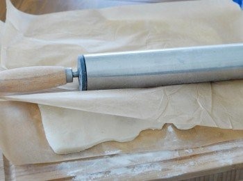 step4: 在枱上灑上步驟一的糕粉，放上蒸熟的粉團. 在上面放一張牛油紙，然後擀薄 （＊一定要在粉團熱的時候擀）