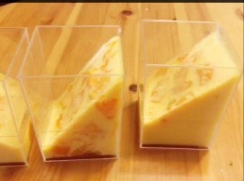 step6: 芒果雙色布丁做法：
剩餘的芒果布丁液，倒入已放有芒果粒的啫喱杯內，全部份量大约杯的一半。