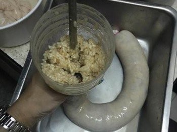 step12: 備一個容器，並且可用繩子降大腸的一端先綁活結，另一端則套在瓶口，開始灌糯米腸，用筷子將糯米戳進瓶口，並適時的擠壓糯米到大腸的另一端，重覆這些動作，直到大腸灌滿；