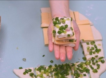 step4: 將<span class="group_1">麵糰</span>平均切成10-12份，一份葱<span class="group_1">麵糰</span>、一份芝士<span class="group_1">麵糰</span>梅花間竹地叠起，平放入模具或烤盤再發酵至2倍大。