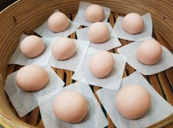 step1: 全部材料混合搓至三光，大概10-15分鐘，將所有白麵團加入1-2克紅麴粉搓成粉色麵團、拎40克粉色麵團再加多少許紅麴粉搓成淡粉紅色麵團；將粉色麵團平均分成14份、每份35克，每一次滾圓前都要搓長條、滾圓包入3克朱古力釘，搓成立體橢圓形做豬仔身體放置於蒸包紙上（造型如圖）