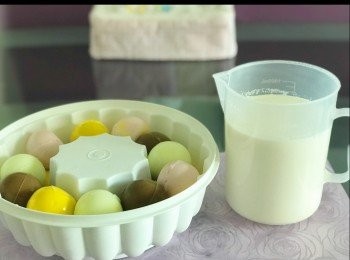 step16: 把彩色布甸球放進<span class="group_3">模具</span>， 再把牛奶布甸溶液倒進去。

我的布甸<span class="group_3">模具</span>為直徑22cm/6cm高，但水信玄餅模直徑是5cm, 所以有部分的布甸球會「跑出來」。如果買到直徑4cm的水信玄餅模就更好， 可以排兩層完整的布甸球， 現在我把其中一層放了已切半的布甸球，但仍會有少少突出水平面。