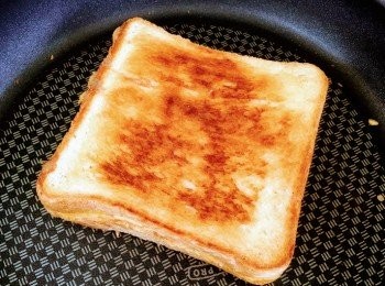 step6: 中火煎麵包2分鐘，另一面又煎2分鐘，熱力能使芝士溶於麵包內。芝味滿溢嘅香烤芝士三文治完成了！要趁熱吃啊！