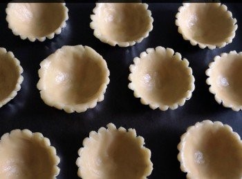 step3: 焗爐預熱180度。粉團分成32份，搓圓放入撻模，用手指沿模具按壓做成撻皮。放入焗爐中焗約10分鐘，取出後放架上待涼。