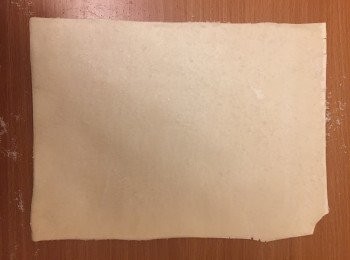 step2: 在工作台上，用篩平均灑下一半糖。
把解凍後的酥皮小心鋪在上面。輕輕掃點牛油。在上面灑下另一半糖、士多啤梨醬、玉桂粉。