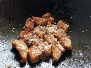 step18: 在燜煮豬大腸時，起油鑊用少少蒜頭，乾蔥將豬肋骨中火煎封