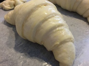 step14: 將牛角包麵團取出，輕力薄薄再塗上一層蛋白液，並且將焗爐預熱至180度。