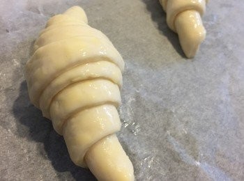 step12: 準備一張焗爐紙放焗盤上，再將牛角包造型麵團放上，用掃薄薄塗上一層輕輕打發的蛋白液。