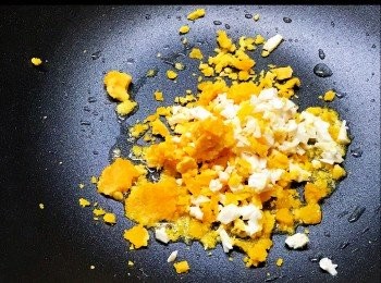 step8: 用新鑊，加兩湯匙油， 油滾後， 把蛋黃碎和咸蛋白加進去，快速不停攪拌， 把蛋黃碎煮鬆。