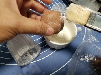 step13: 將月餅模及每個月餅都要掃上底筋粉,再澄出多餘粉,否則太多粉會影響花突出效果(每做一個月餅都要掃1次粉)