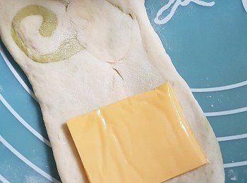 step9: 之後將麵糰再桿平多一次， 把芝士片一遍又一遍的鋪在麵糰之(底面上)