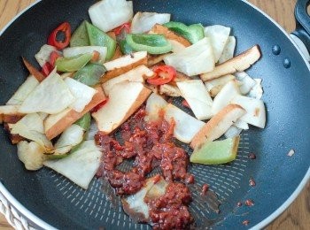 step2: 下青椒、椰菜和豆腐乾，拌炒均勻，再加入辣豆瓣醬、麻油、鼓油和糖，拌勻