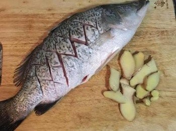 step2: 薑切片，魚身略切痕，除了可以方便蒸煮之外，在淋醬後能更入味。將薑片塞入魚肚中，滾水蒸20～25分鐘（取決於魚的大小，小於1公斤的蒸15-18分鐘即可）