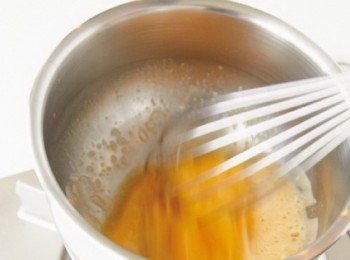 step2: 在調理盆中將蛋打散成蛋液，加入細砂糖拌混。將調理盆底部浸到熱水中，並用打蛋器攪拌蛋液