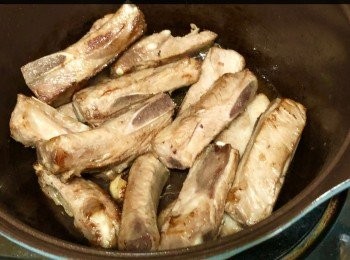 step5: 燒熱油鍋，加入蒜頭、薑爆香，放入肉排煎至表面金黄微焦。