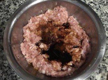 step4: 絞肉中放入鹽與黑胡椒粉抓勻，將1/3杯的水,分兩次拌入絞肉中，每次都要攪拌到水份完全被絞肉吸收；放入醬油、糖與香油拌勻到產生黏度；