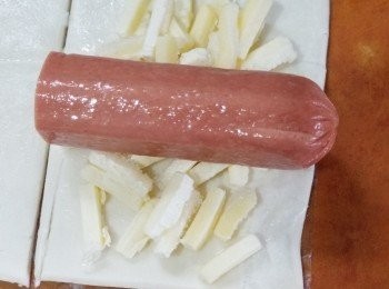 step2: 酥皮上放上芝士碎，腸仔，卷好