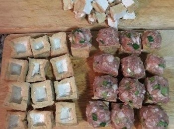 step6: 油豆腐選平整的ㄧ面，用小刀切出一個方型後，將中間掏出，掏出的油豆腐可留下等一會與<span class="group_3">醬汁</span>同煮。接著將拌好的絞肉塞入油豆腐中間，需填滿壓緊，讓絞肉高出油豆腐的高度即可。