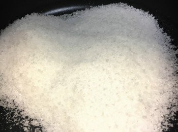 step5: 打開鍋蓋將粗海鹽炒香(約2分鐘)，將紙包魚放上海鹽上面，將鍋邊海鹽盡量推向魚兩面。