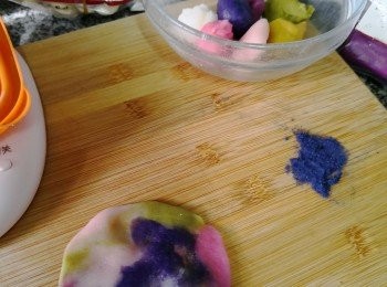 step3: 混色搓扁後轆成平滑便可包入紫薯包入melt kiss朱古力軟心，用掃好椰子油的月餅模印出來