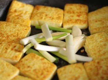 step2: 接著將冰糖、大蒜、青蔥下鍋炒出香氣，且冰糖溶化、稍微出糖色。