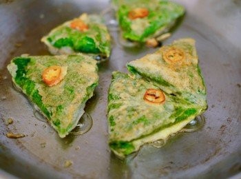 step10: 在一個煎鑊中，開中火，放油一湯匙，煎餅沾了雞蛋後，放到鑊中煎好。先煎有接口的一邊，然後番過另外一邊再煎。

紅椒粒沾一點雞蛋後，放在煎餅中間一起煎熟