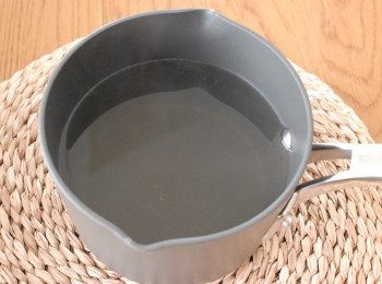 step2: 將餘下的水和牛奶放入煲內，煮熱後下糖，煮至糖溶化，再加入魚膠粉溶液和杏仁香精拌勻