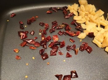 step3: 白鑊炒菜甫粒炒到乾身，之後再加入乾辣椒和花椒爆香。