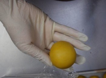 step21: 再搓成圓球，要完全一丁點裂縫也不可以有，如果奶黃，餡份量太多，或天氣太熱，摸到想有溶化的跡像，即停止包餡，將奶黃餡放冰箱雪硬再做