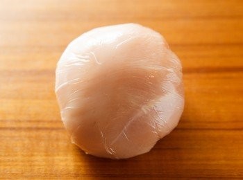 step3: 將雞肉從各個方向往中間包，並利用保鮮膜將雞肉捲起來成一個球狀後，丟進冷凍庫，冰30分鐘。(冰的動作是要讓雞肉定型，如果省略內餡的奶油很可能會流出來，所以冰的動作非常重要。)