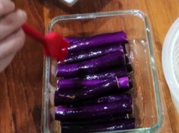 step2: 將浸泡過鹽水的茄子平均鋪排於保鮮盒中，
茄子表面均勻刷上食用油