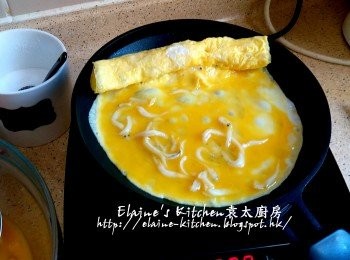 step9: 卷好後 , 推至煎pan邊邊位置 , 再用廚房紙抹一抹油 , 再加入白飯魚蛋液 , 同樣煎約1分鐘時間