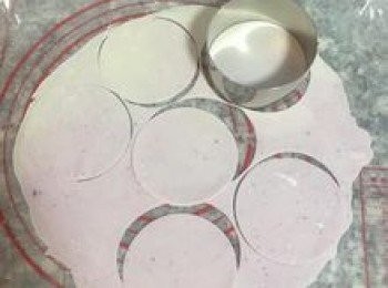 step22: 用中型圓型模具壓出圓片即可；剩下的麵皮集中起來，ㄧ隻手沾濕後將麵皮再捏成糰後，便可重複壓擀的動作。