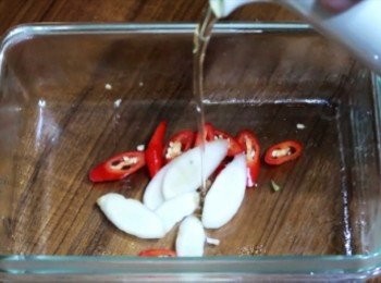 step2: 保鮮盒內加入適量食用油，擺入嫩薑片和紅辣椒，
入微波，大瓦數微波1~2分鐘(有聞到香味即可取出)