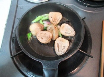 step2: 取小鍋子,放入步驟1的蔥白與欖角,酒,味霖及鹽煮滾出香氣,續放入步驟1的鮮草菇拌勻.