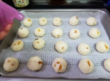step7: 焗盆放入牛油紙，再將混合好的粉團平均分成20粒，搓成球狀，并排放入焗爐盆中、入爐前噴水在粉團上