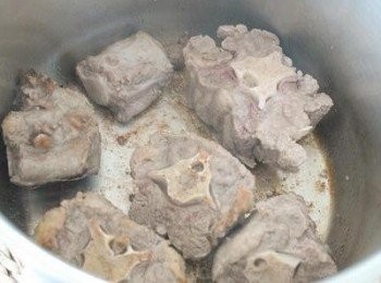 step2: 在大煲內，下點橄欖油，下牛尾骨和牛肉，下鹽和黑胡椒粉調味，煎至微焦，拿出肉備用